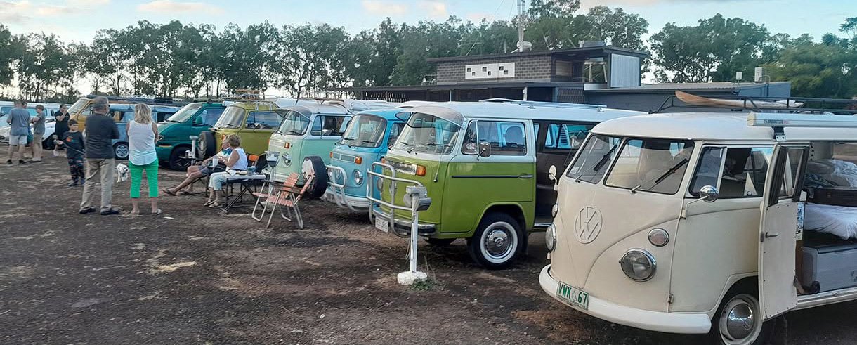 A row of Kombis parked at dusk